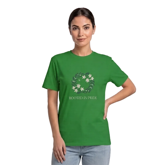 A woman modeling a green short-sleeve t-shirt with a circular floral graphic and the text 'ROOTED IN PRIDE' on the front, paired with light blue jeans against a plain light gray studio background l AH Urban Wear Pk