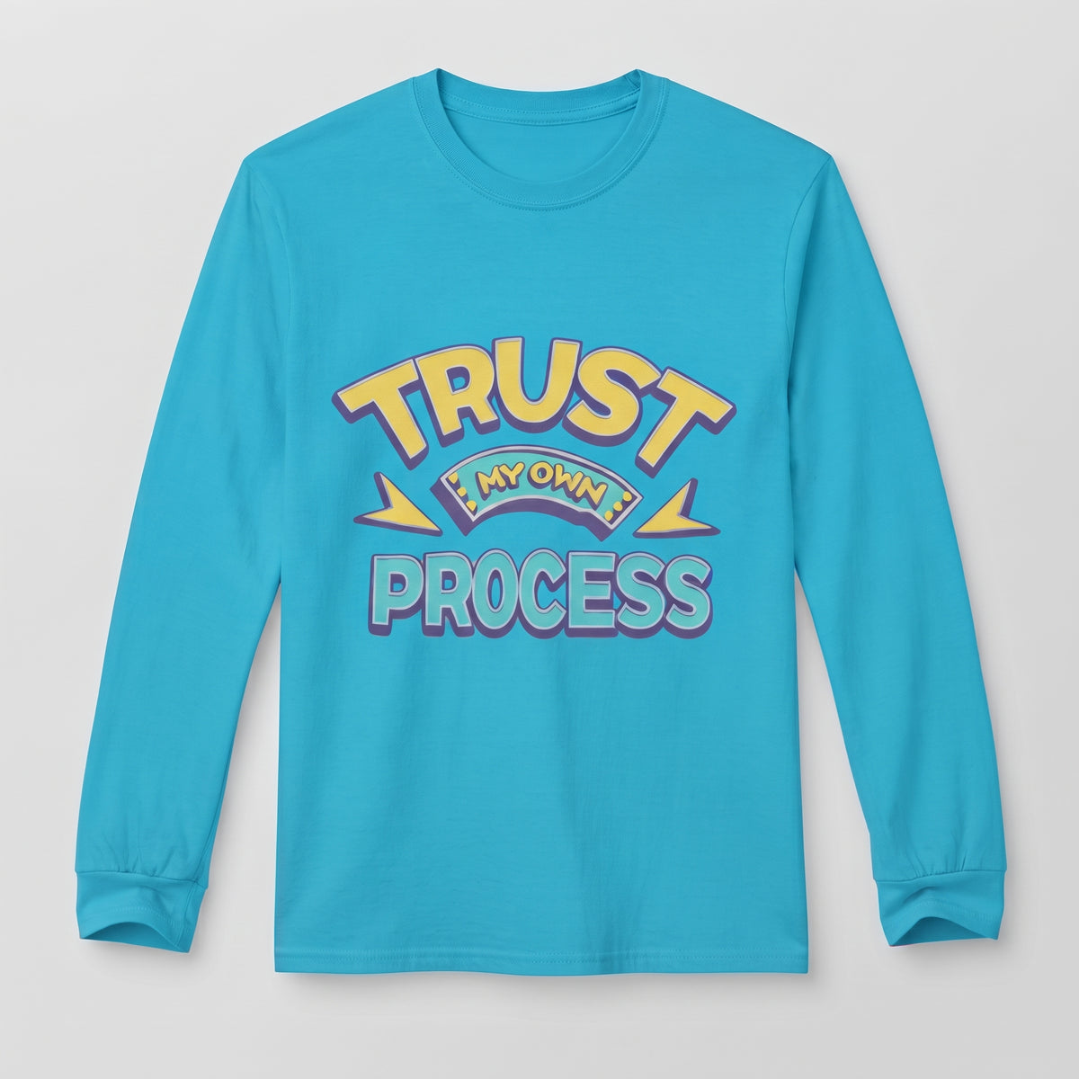 A bright turquoise long-sleeve t-shirt with a retro-style graphic on the chest reading 'TRUST IN MY OWN PROCESS' in yellow, purple, and blue lettering, displayed against a light gray background l AH Urban Wear