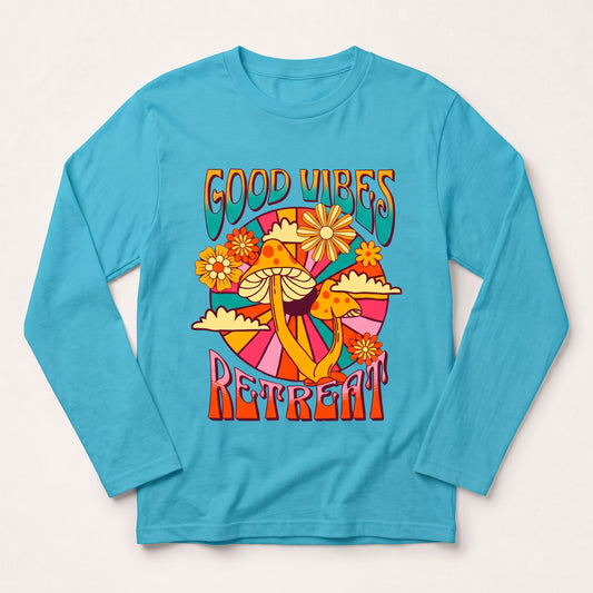 A turquoise long-sleeve t-shirt with a colorful retro 70s-style graphic on the chest featuring mushrooms, flowers, and the text 'GOOD VIBES RETREAT' l AH Urban Wear