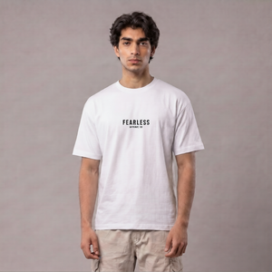 A man wearing a white crewneck t-shirt with 'FEARLESS' printed in black on the chest, paired with beige cargo pants, standing against a neutral gray studio background | AH Urban Wear PK