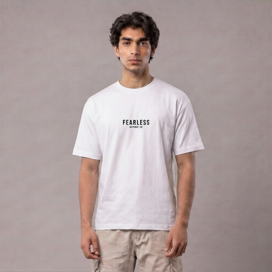 A man wearing a white crewneck t-shirt with 'FEARLESS' printed in black on the chest, paired with beige cargo pants, standing against a neutral gray studio background | AH Urban Wear PK