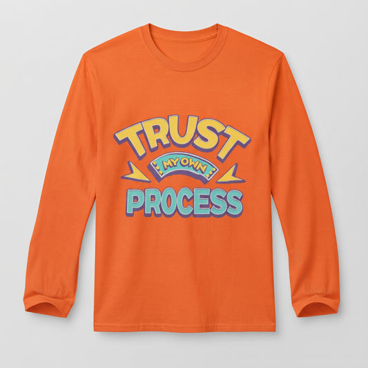 An orange long-sleeve t-shirt with a retro-style graphic on the chest that reads 'TRUST IN MY OWN PROCESS' in yellow, blue, and purple lettering, displayed on a light gray background l AH Urban Wear