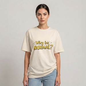 A woman modeling a cream-colored drop shoulder t-shirt with the text 'Why be NORMAL?' printed in yellow and black on the front, paired with light blue jeans, against a plain light gray background | AH Urban Wear PK