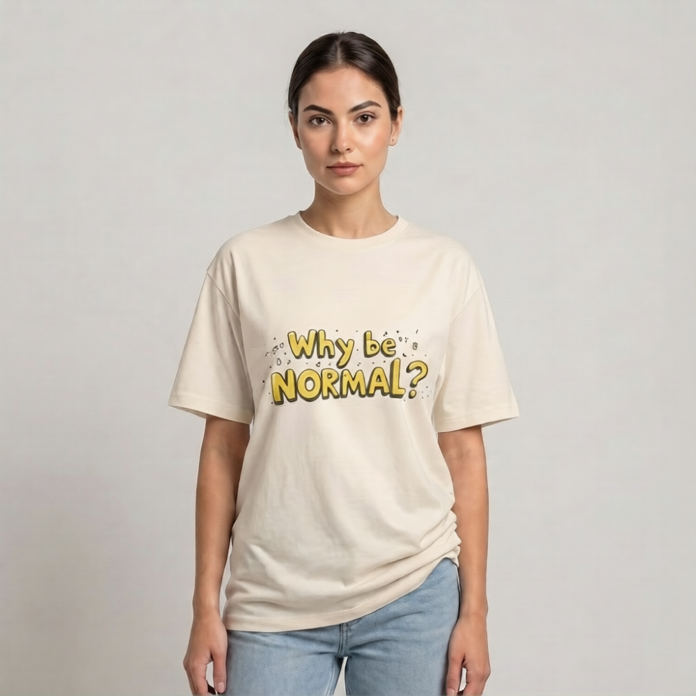 A woman modeling a cream-colored drop shoulder t-shirt with the text 'Why be NORMAL?' printed in yellow and black on the front, paired with light blue jeans, against a plain light gray background | AH Urban Wear PK