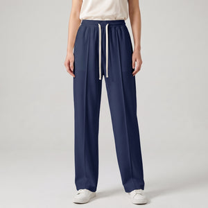 A model is wearing navy blue baggy trouser with white sneakers, shown from the waist down against a light gray studio background l AH Urban Wear