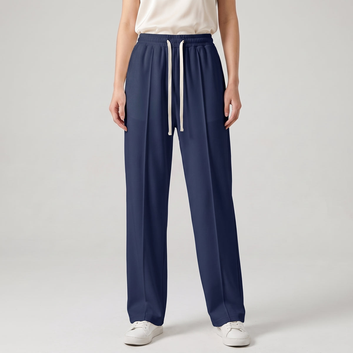 A model is wearing navy blue baggy trouser with white sneakers, shown from the waist down against a light gray studio background l AH Urban Wear