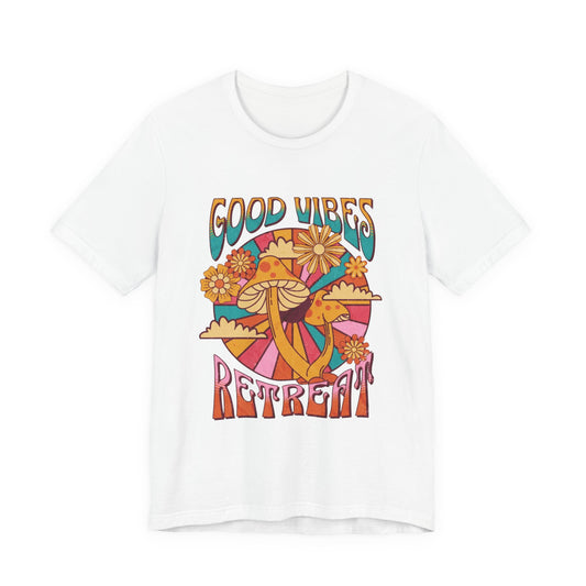 A women white short-sleeve crewneck t-shirt featuring a colorful retro-style graphic with the words 'GOOD VIBES RETREAT' and a psychedelic mushroom, sun, and flower design | AH Urban Wear PK